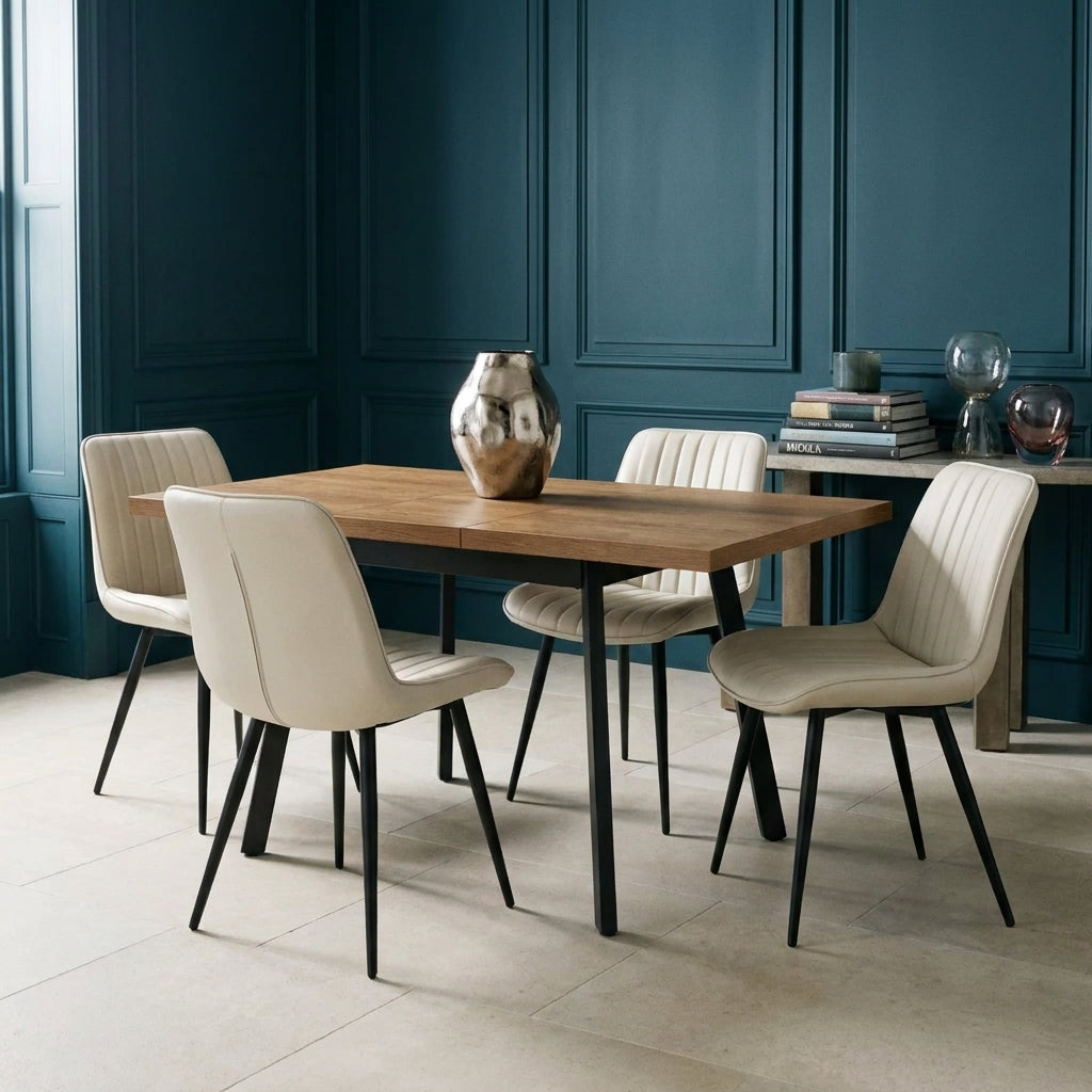 Sloan 5 Piece Extending Dining Set closed, with four chairs, in a dining room with deep petrol blue panelled walls and a pale limestone floor