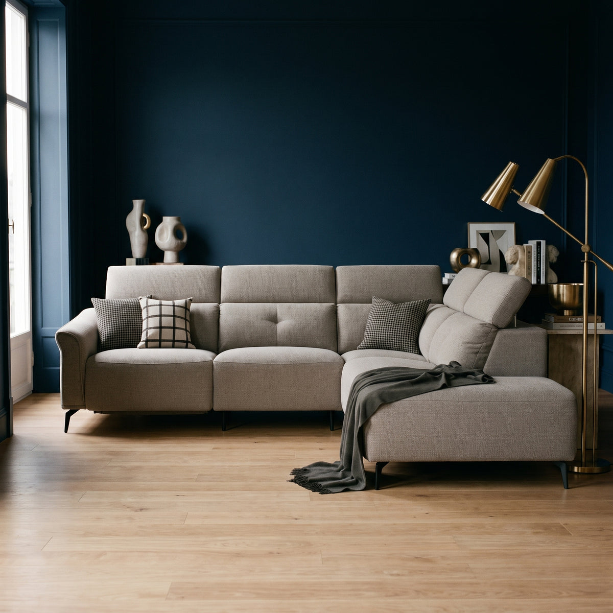 Oscar electric reclining corner sofa in greige woven fabric, styled in a living room with deep ink blue walls and light oak flooring