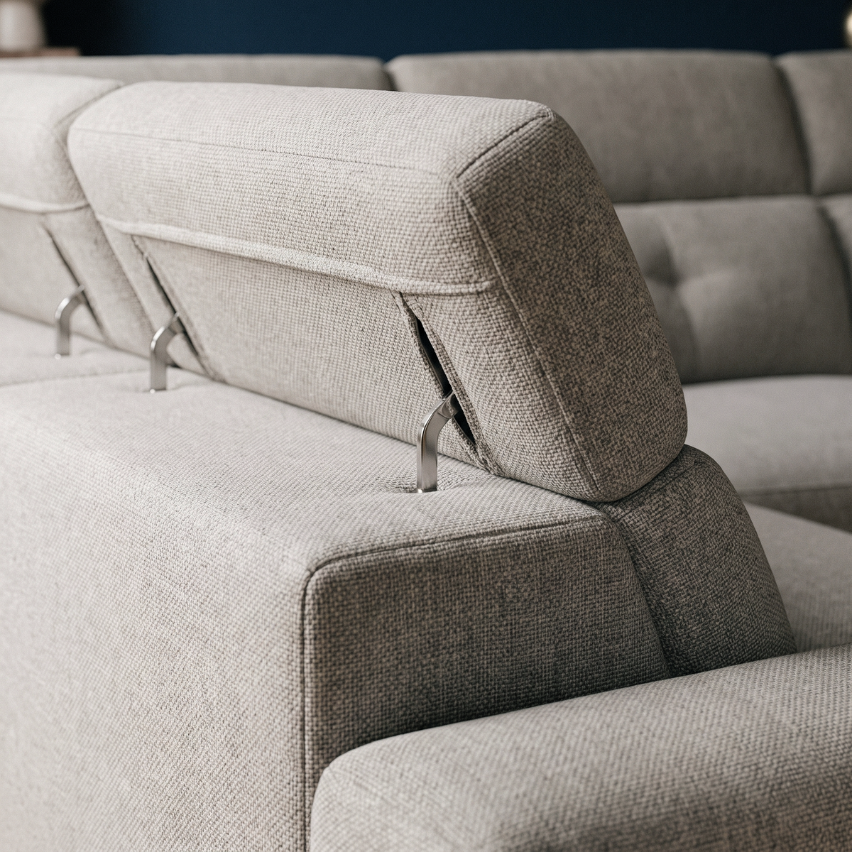 Close up of the adjustable headrest hinge and woven greige fabric on the Oscar corner sofa