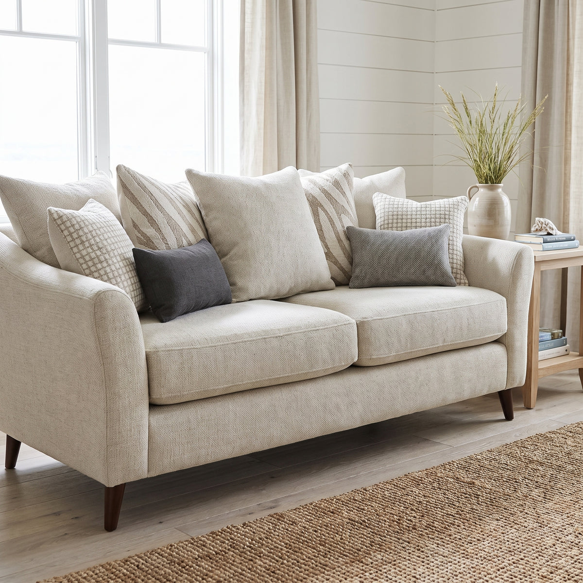Samantha scatter back sofa in oatmeal cream weave, in a bright coastal room with white walls and a seagrass rug