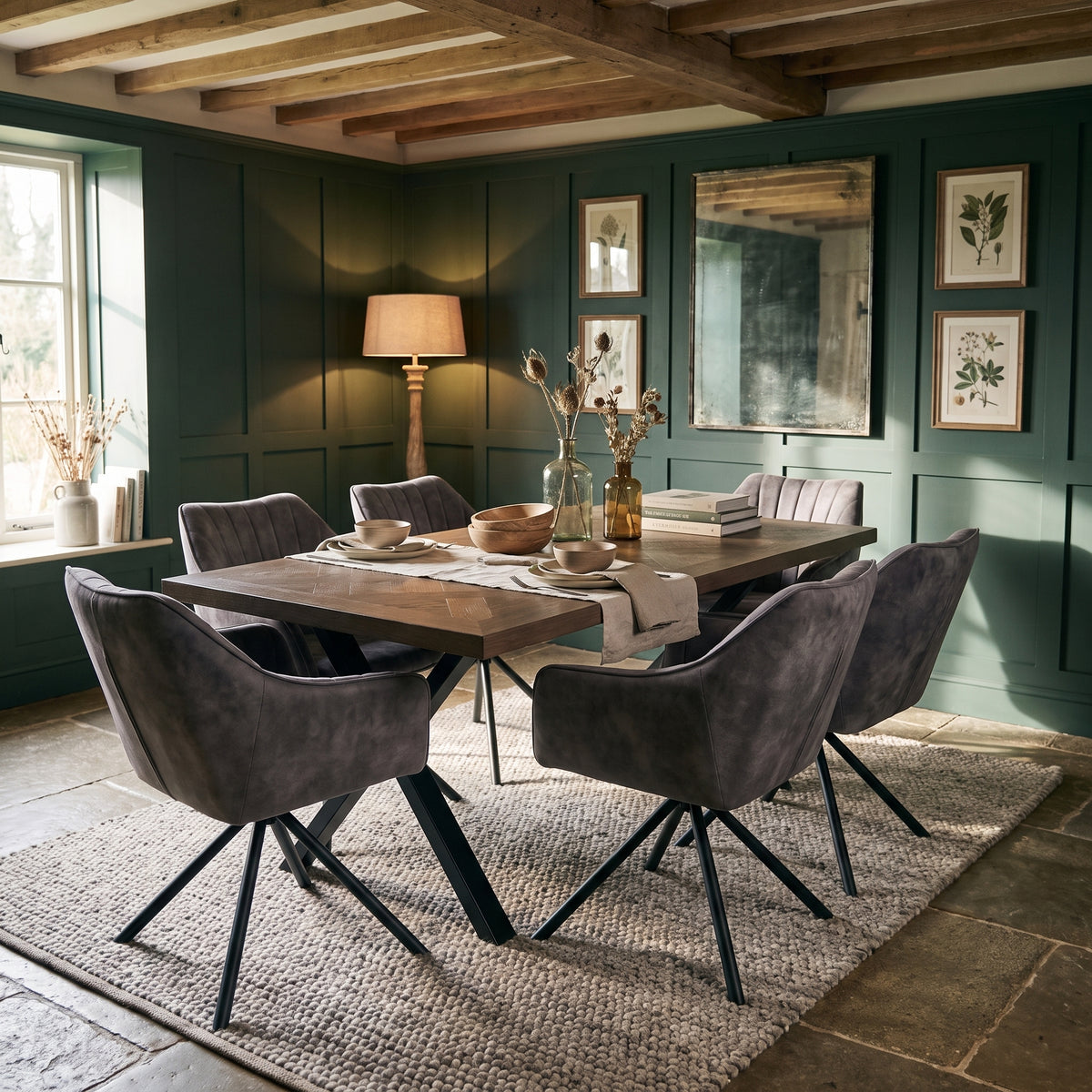 Winston dining set with dark herringbone table and six grey tub chairs, in a panelled room with forest green walls and a flagstone floor