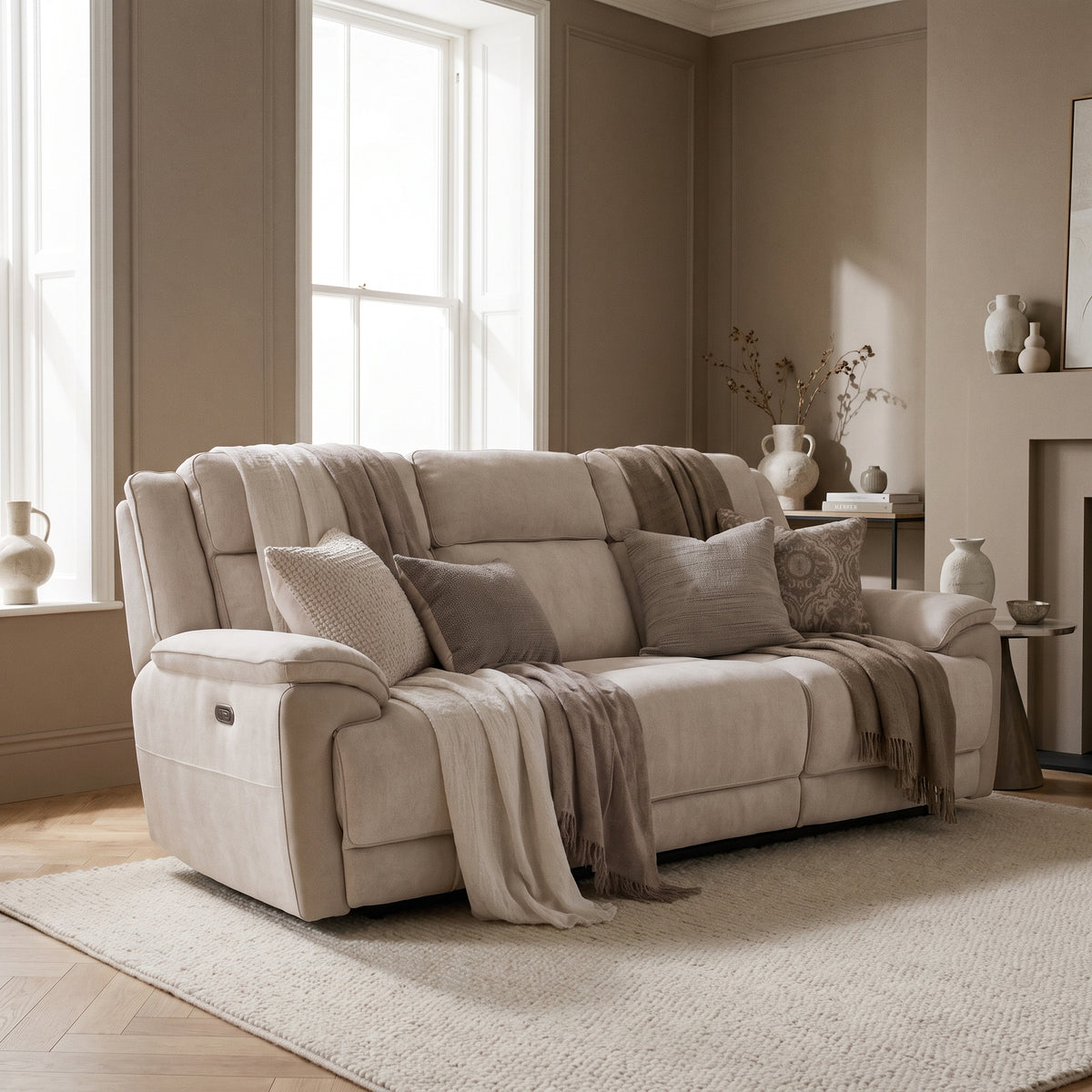 Walton electric reclining three seater in pale cream fabric, in a bright room with taupe walls and light oak flooring