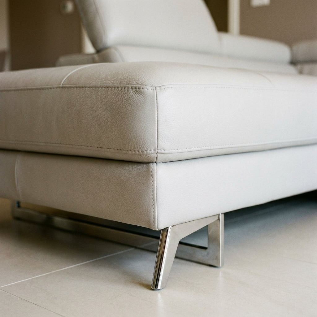 Close up of the stitched leather seam and polished chrome foot on the Kimi corner sofa