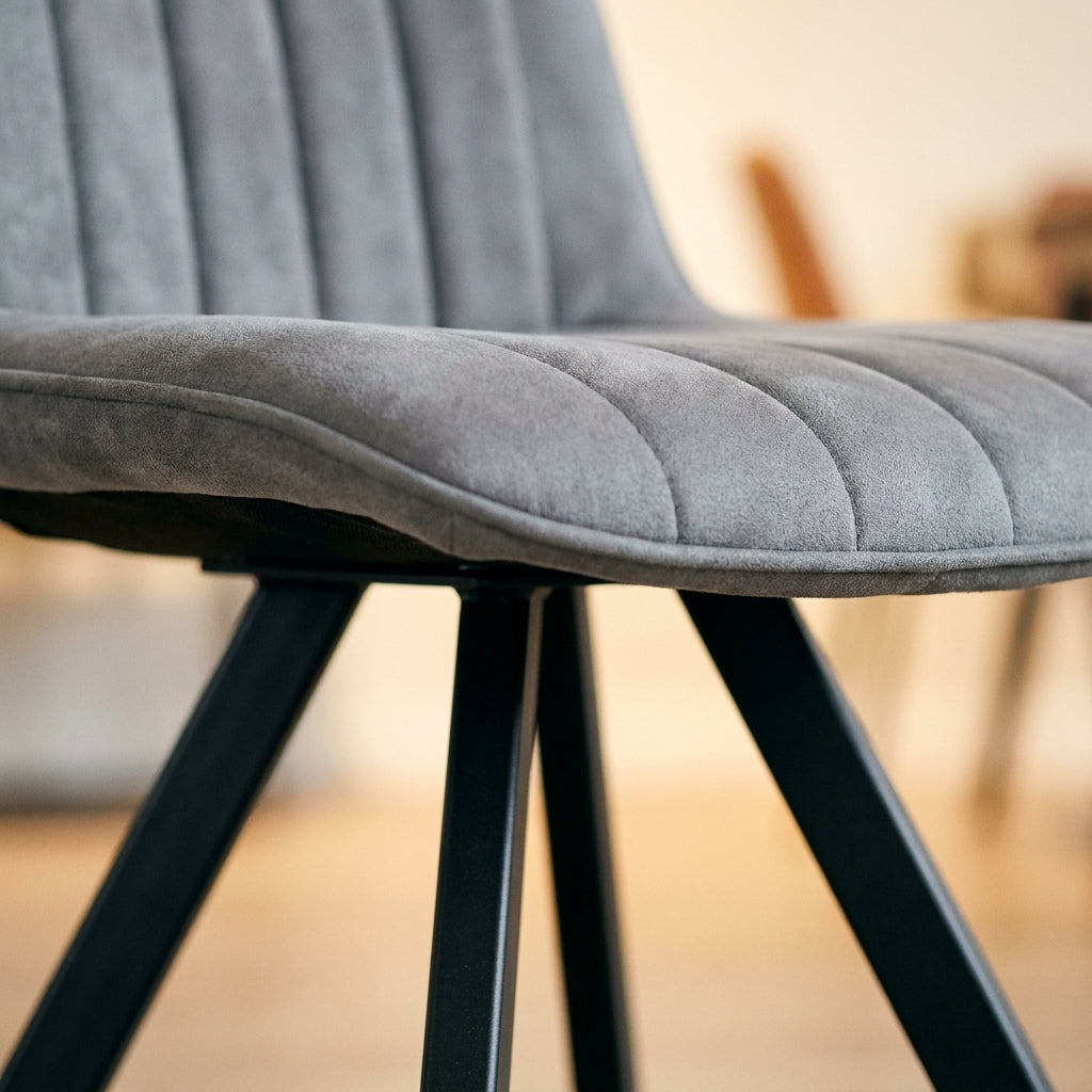 Close up of the fluted grey seat and black splayed metal leg on a Winston dining chair