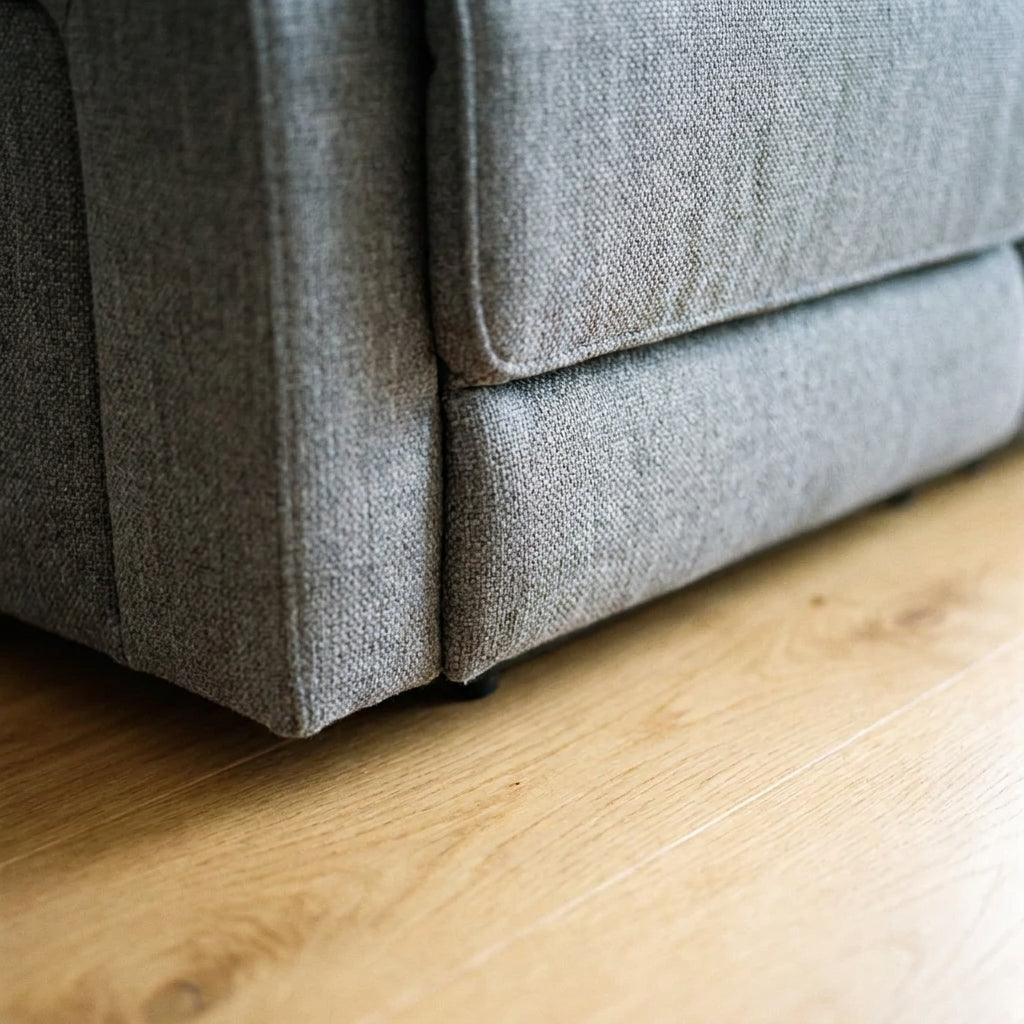 Close up of the plinth base corner and mid grey woven fabric on the Mechelle sofa