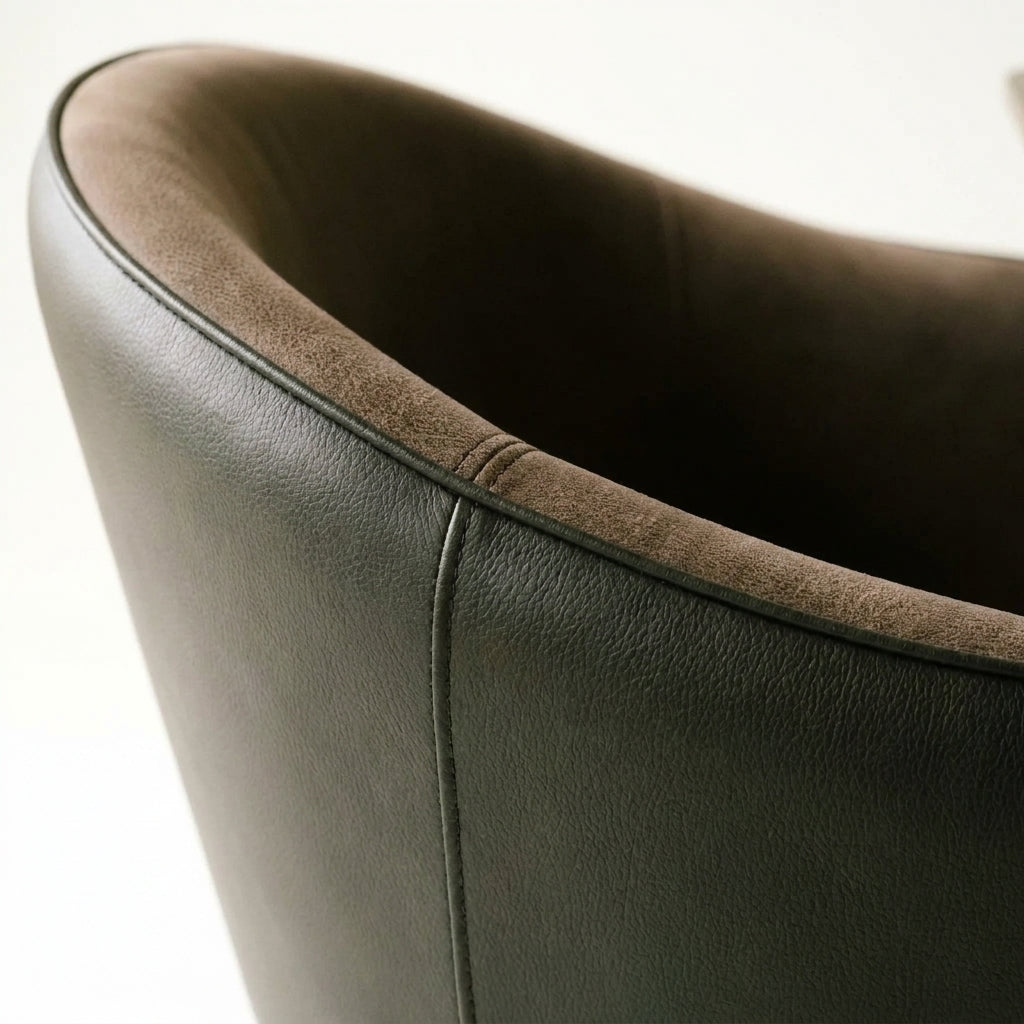 Close up of the curved wraparound back and low arm of a Colorado dining chair in dark leather look fabric