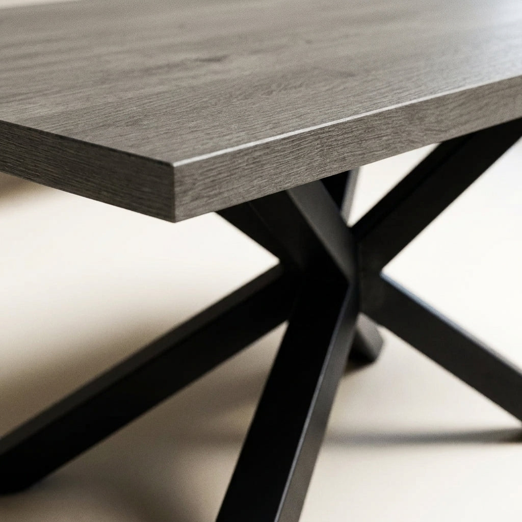 Close up of the grey oak table top corner and black X pedestal on the Benicio dining set
