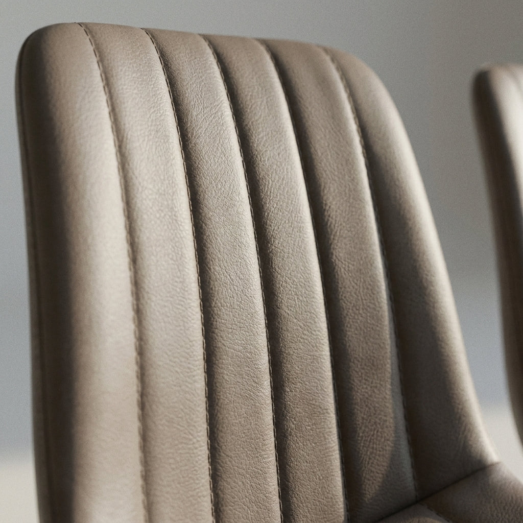 Close up of the vertical channel stitching on the taupe faux leather back of a Christina dining chair