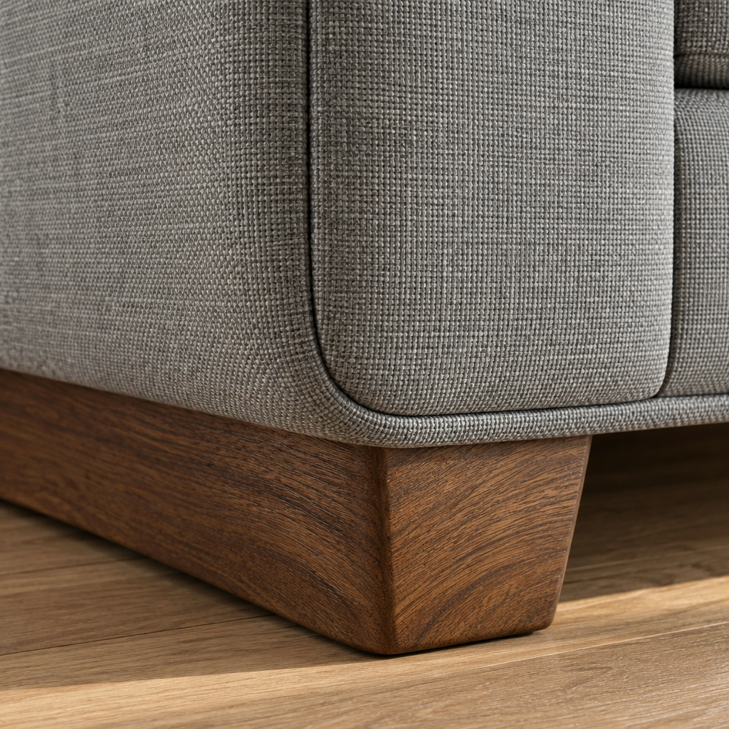 Close detail of the Marcus Sofa wooden sleigh foot and the grey fabric frame above it