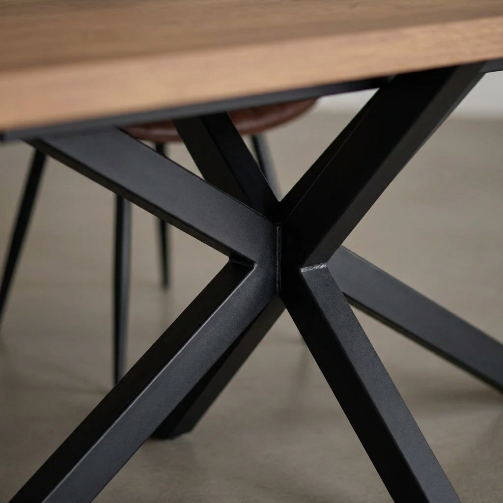 Close up of the black metal cross base beneath the Sloan dining table