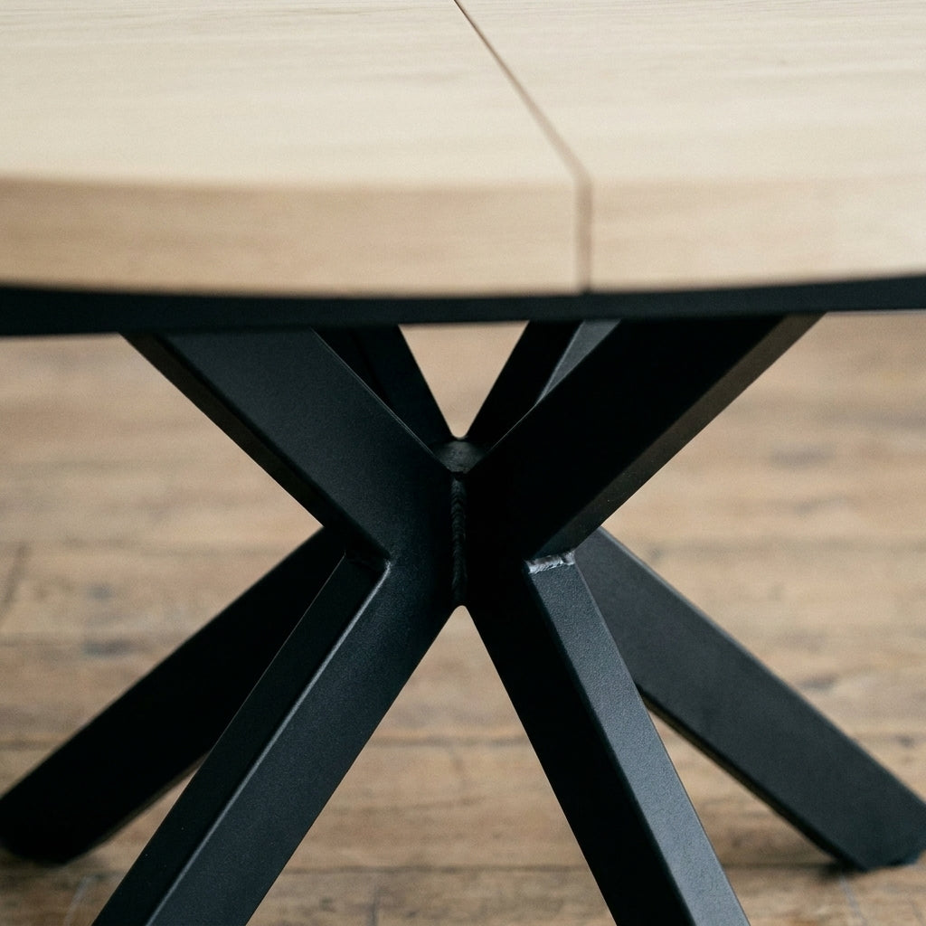 Close up of the black metal cross base and the extension seam on the Sloan round table