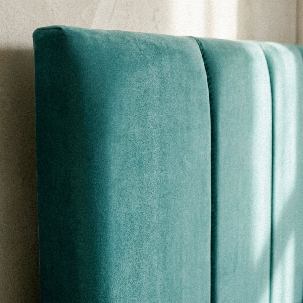 Close-up of the teal velvet channelled headboard on the Juan ottoman bed