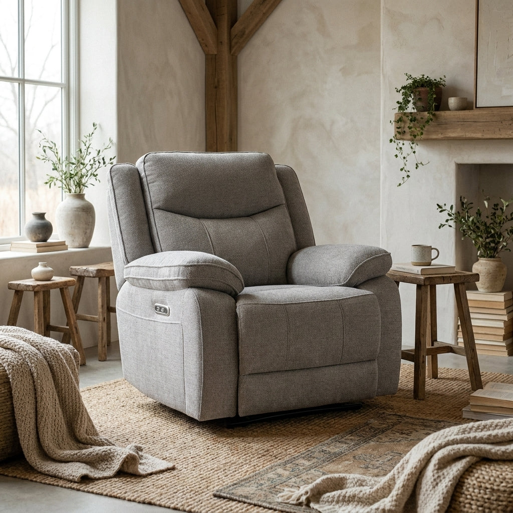 A cozy, modern farmhouse living room featuring a grey recliner chair, rustic wooden stools, and neutral decor on a jute rug.
