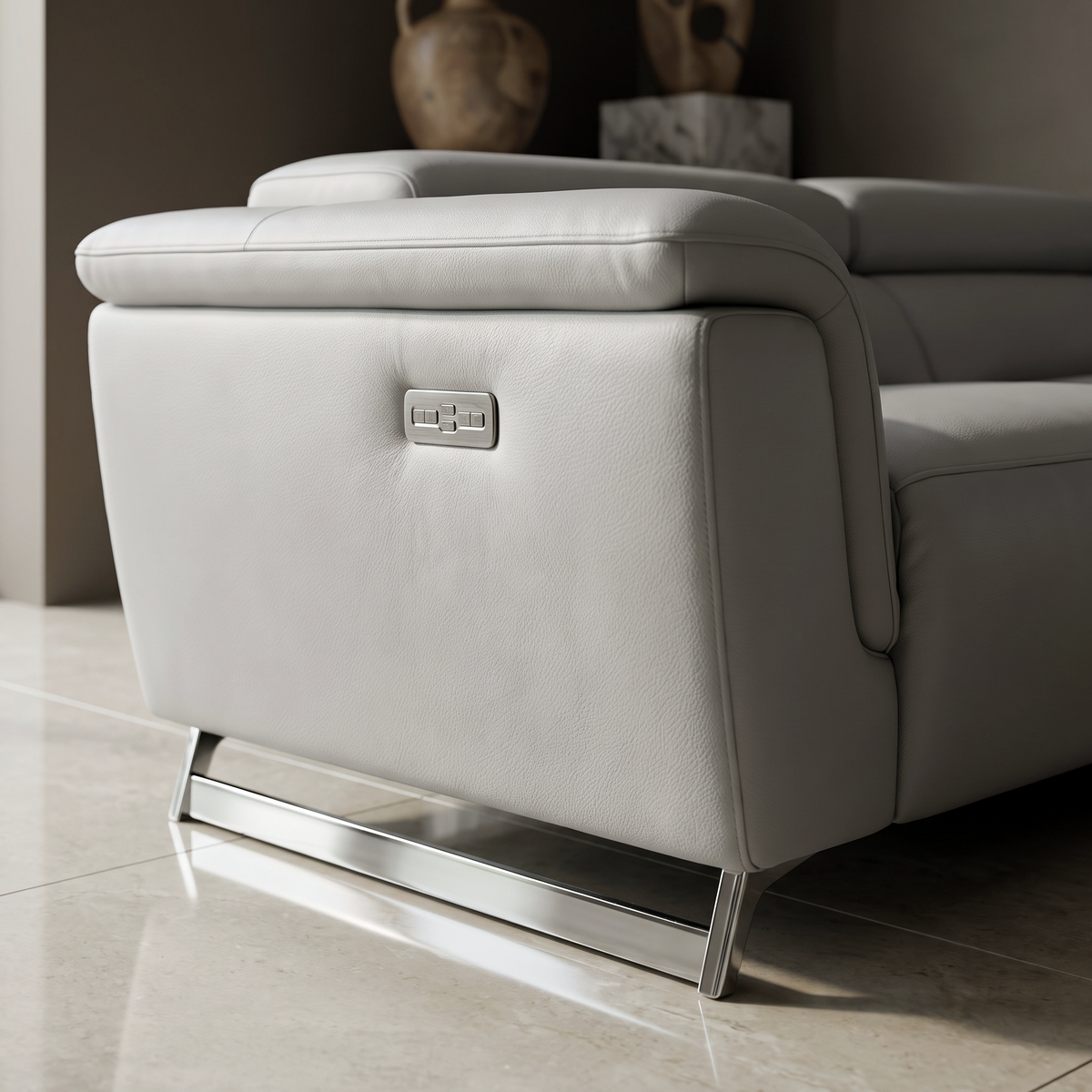 Close up of the Kimi Corner Sofa arm showing the electric recline control panel set into the pale grey Italian leather, with the polished chrome foot below