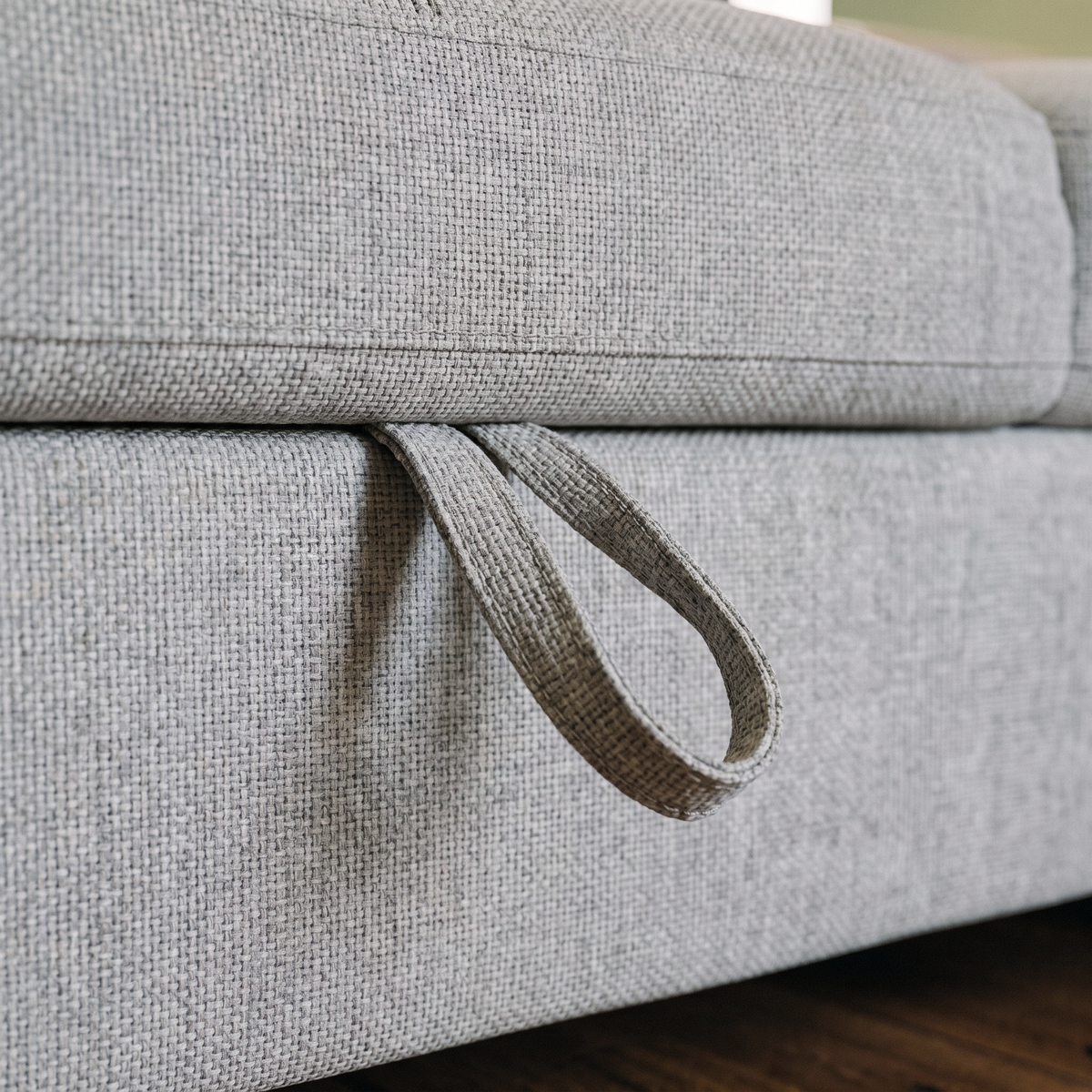 Close up of the fabric pull strap on the storage compartment of the Nemo corner sofa bed