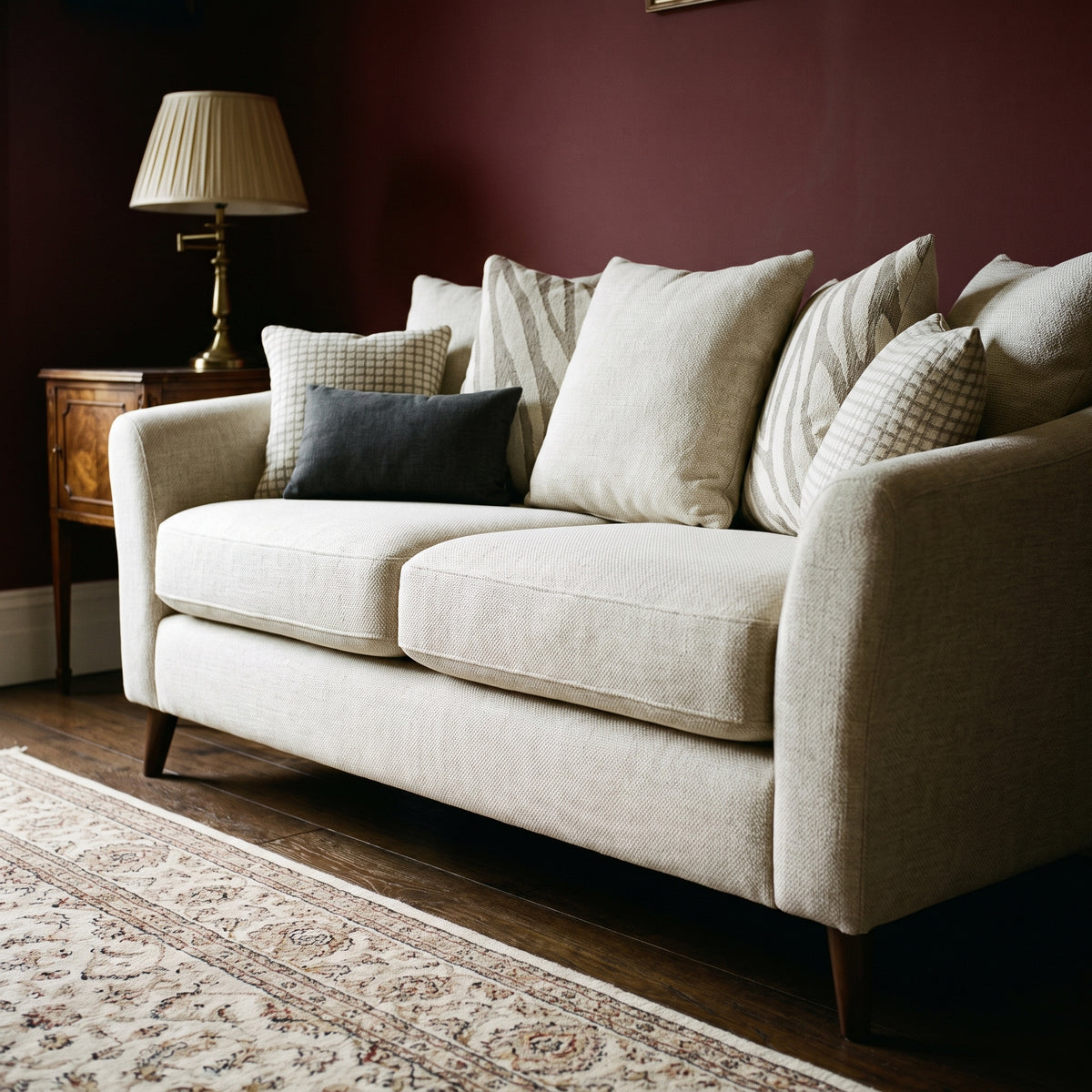 Samantha sofa in oatmeal weave against deep burgundy walls with dark oak flooring and a patterned wool rug