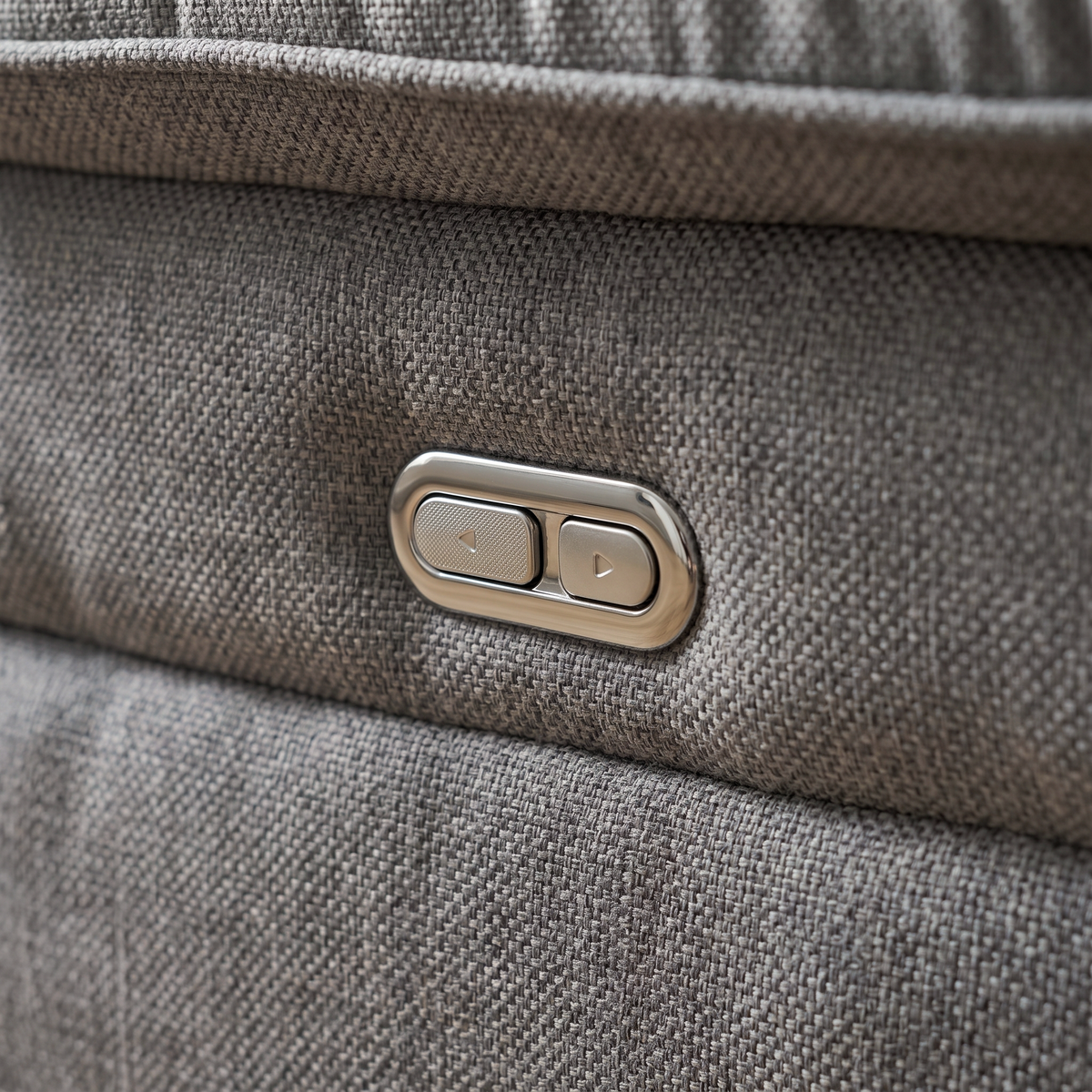 Close up of the chrome recline control button on the arm of the Mechelle electric reclining sofa