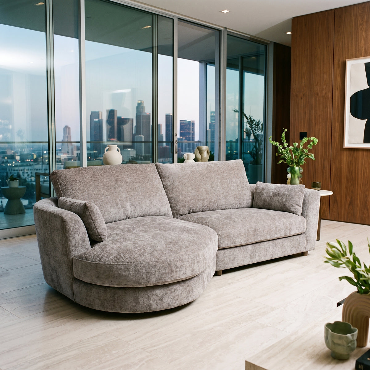 Persia curved chaise end sofa in a contemporary apartment with floor to ceiling glass and a pale marble floor