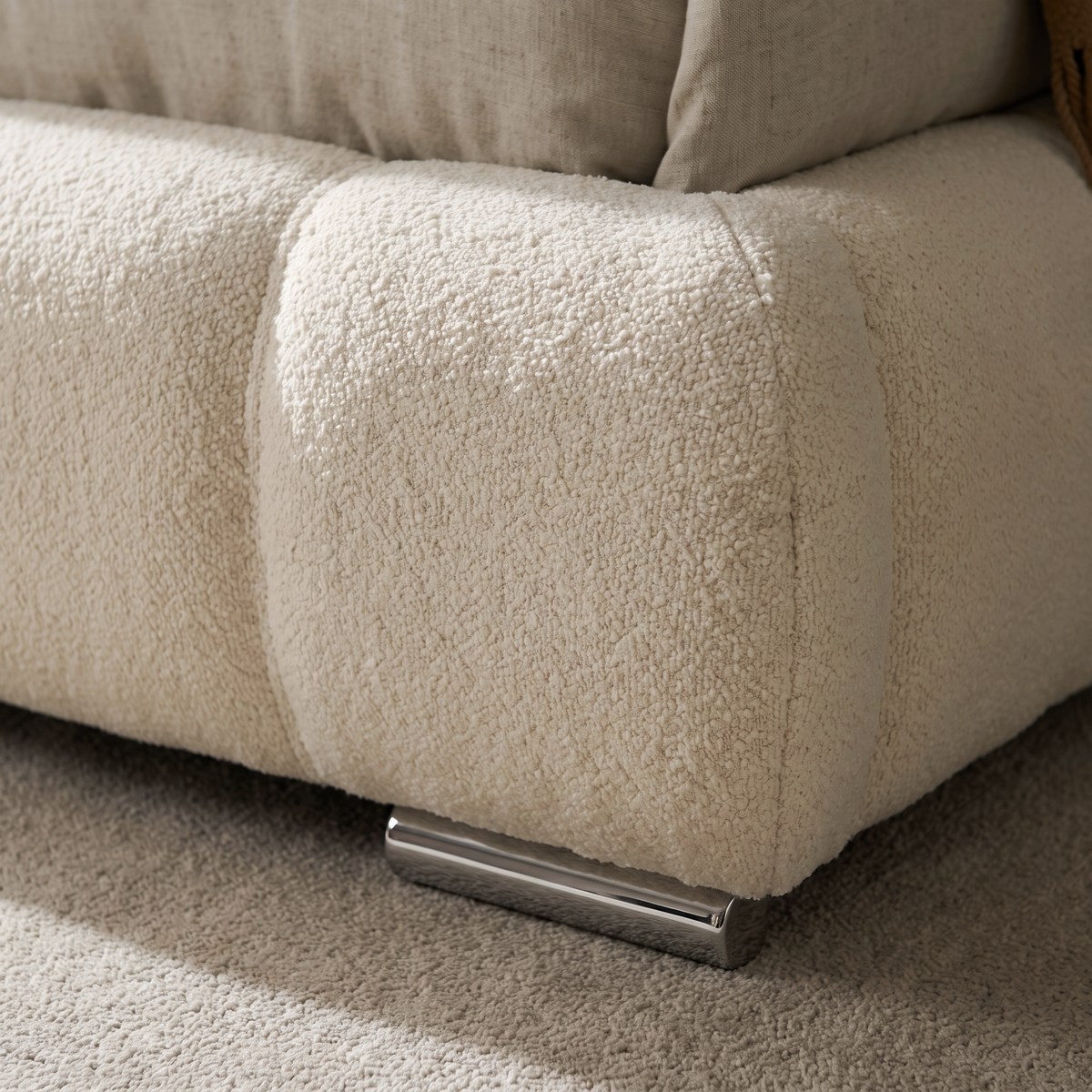Close up of the puffed cube quilting, cream boucle and chrome foot on the Utopia ottoman bed