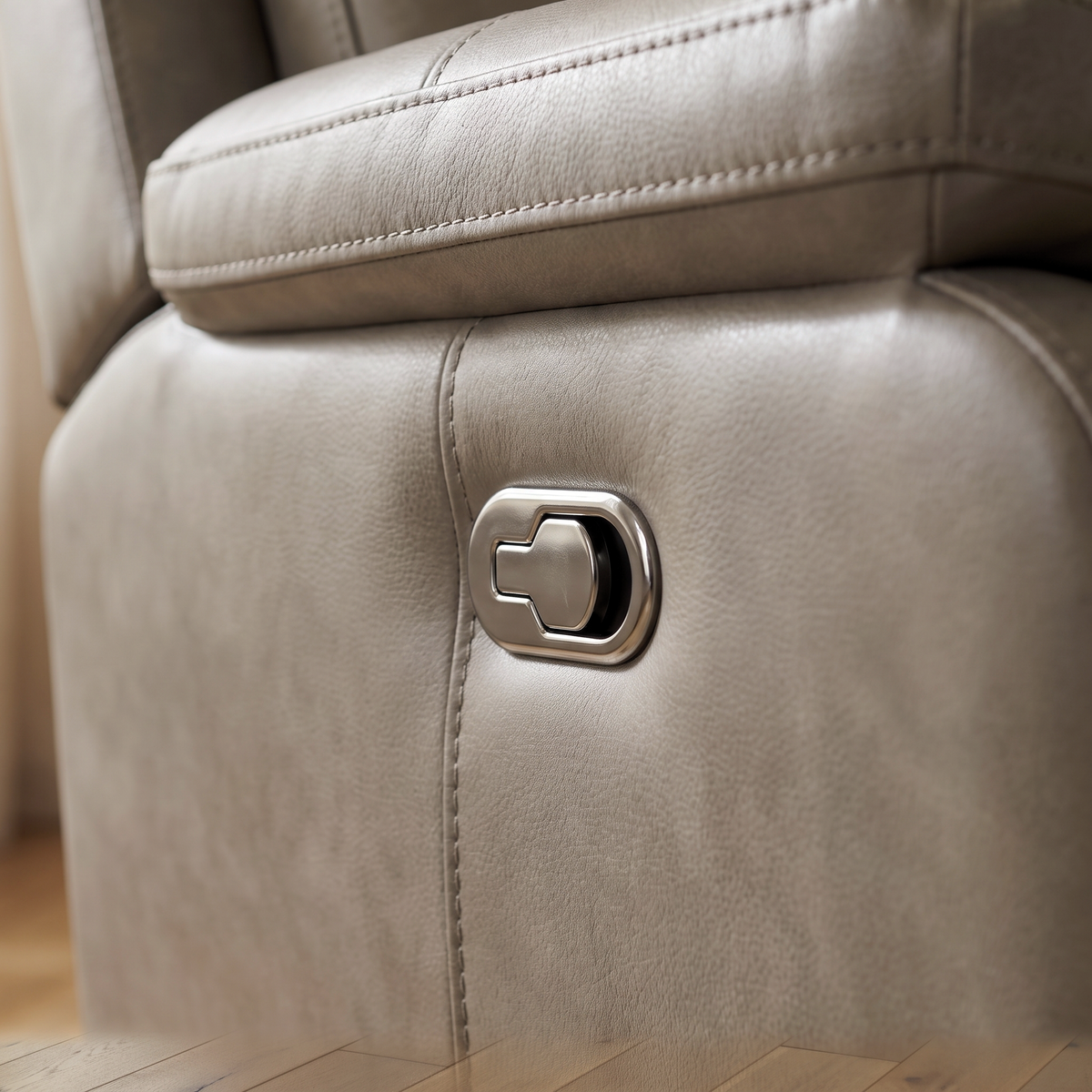 Close up of the chrome recline control button and leather stitching on the Grace reclining sofa
