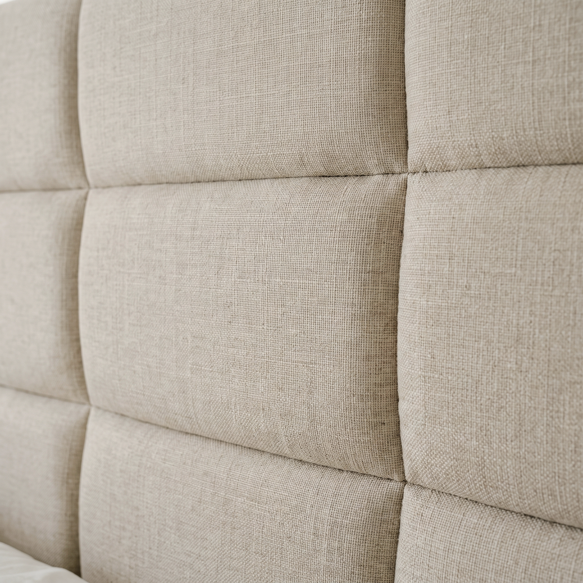 Close up of the panel quilting and oatmeal linen weave on the Kratos ottoman bed headboard