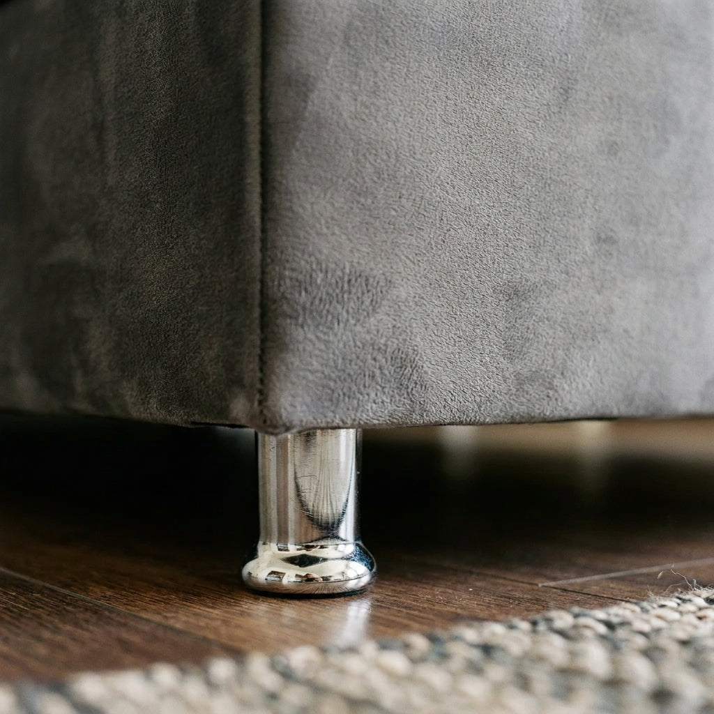 Close up of the chrome foot and grey velvet base on the Luxor ottoman bedframe