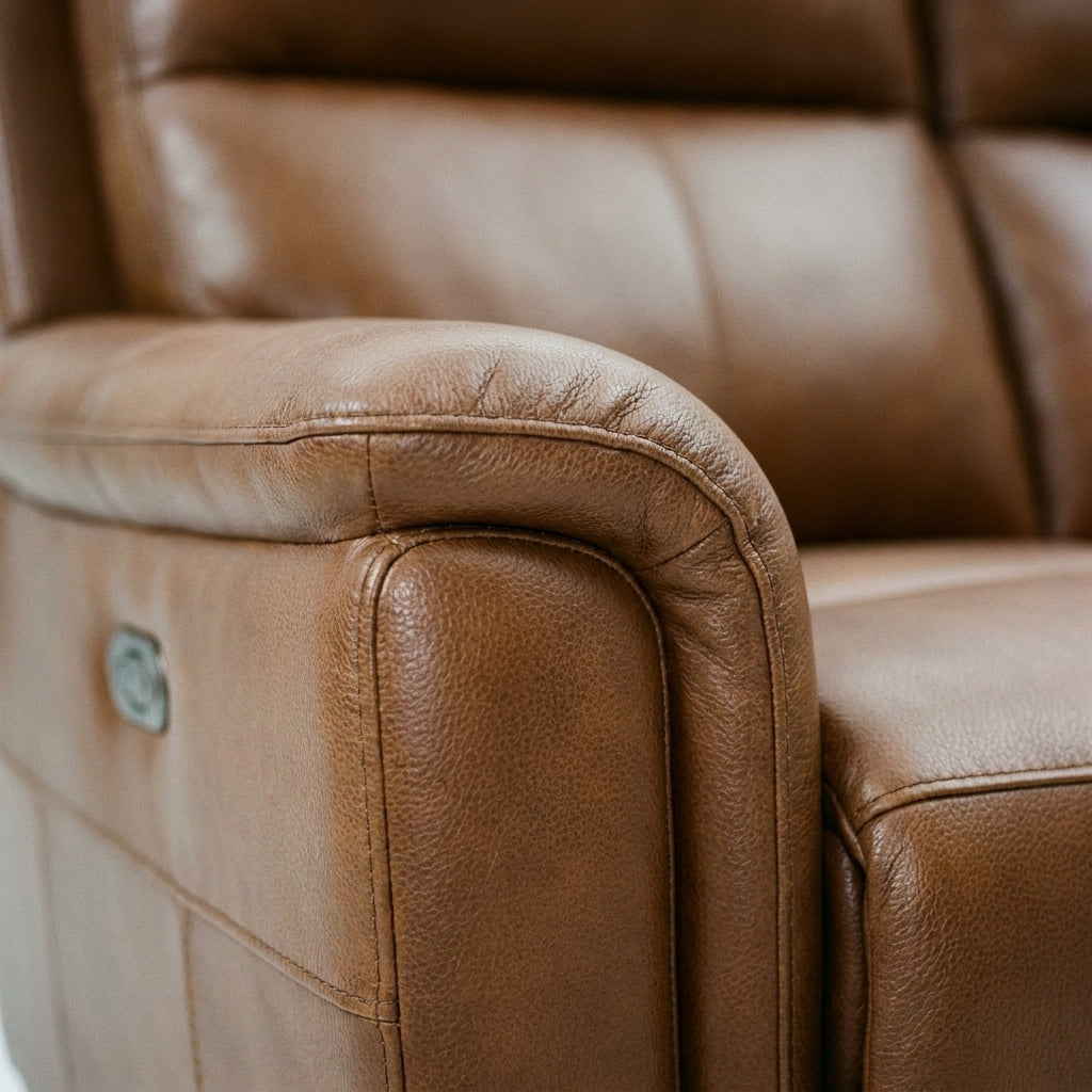 Close up of the scrolled arm, stitching and tan leather grain on the Sterling recliner