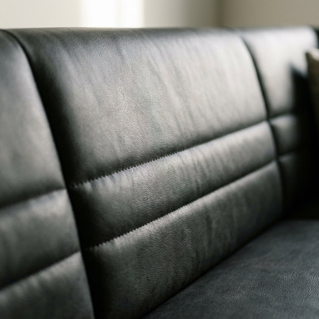 Close up of the horizontal channel stitching on the dark leather look back of the Moore corner bench