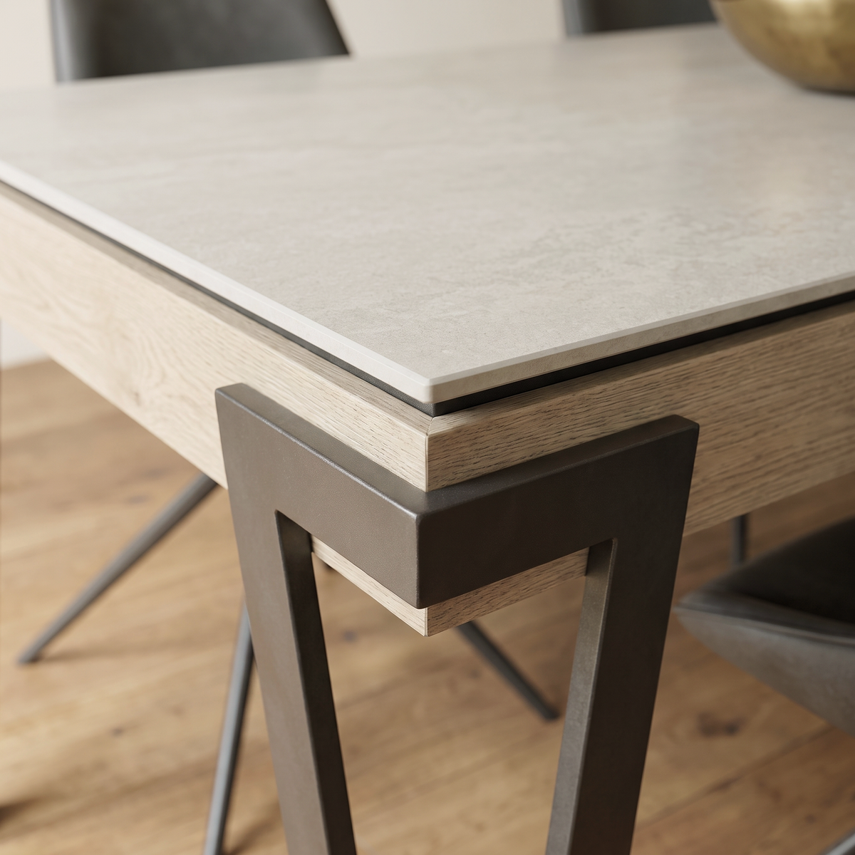 Close up of the pale ceramic table top corner and light oak frame on the Giorgio dining set