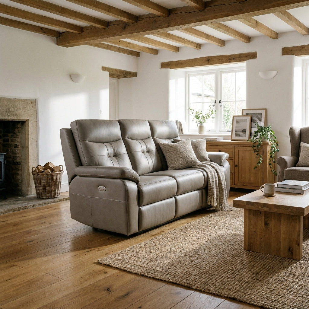 Grace taupe leather electric reclining sofa in a beamed cottage living room with a stone fireplace