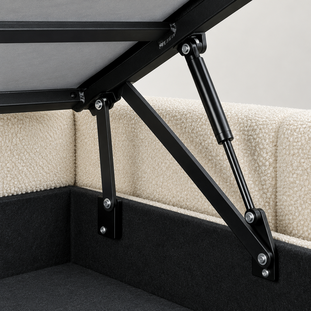Close-up of the Utopia motorised ottoman bedframe lifting mechanism, showing the black lifting arm and linkage against the cream boucle base and lined storage well