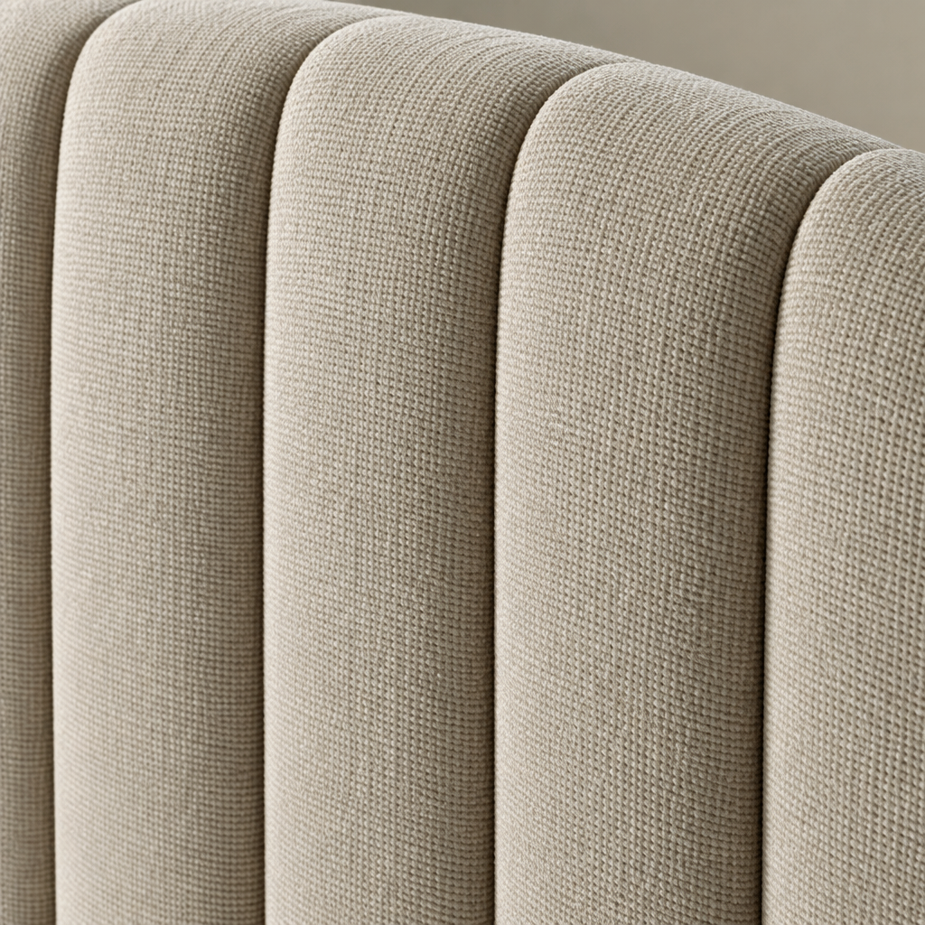 Close detail of the Dusk Bedframe headboard showing the oatmeal fabric and the vertical channelling following the curved top edge