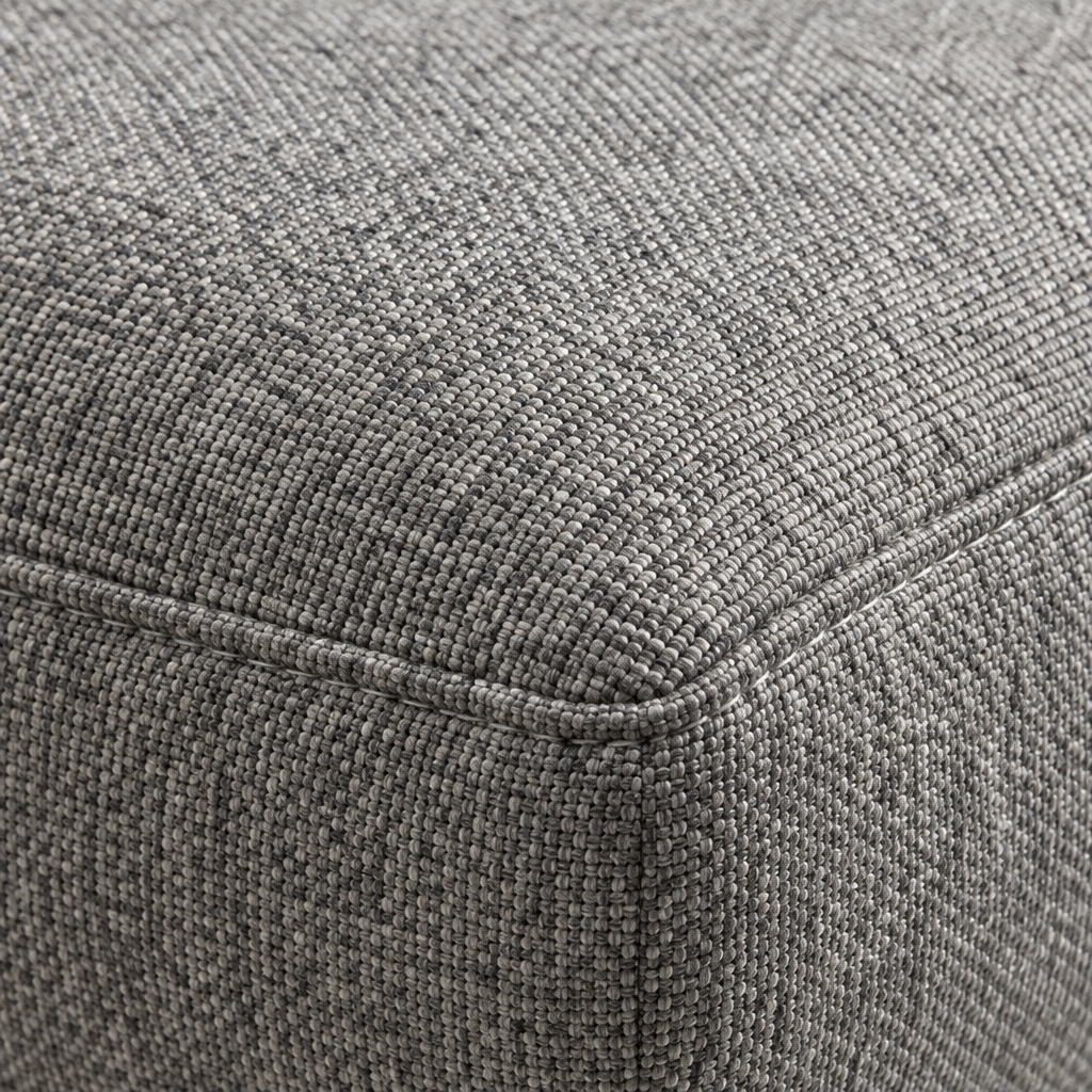 Close detail of the Kirk Swivel Chair's matching footstool in flecked grey fabric